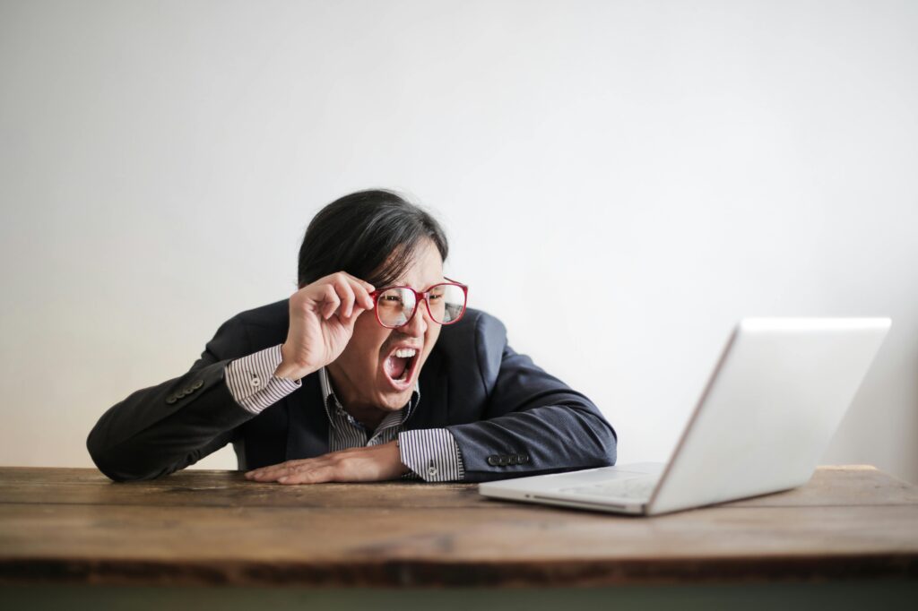 pexels photo 3760778 3760778 Modern Asian man in jacket and glasses looking at laptop and screaming with mouth wide opened on white background